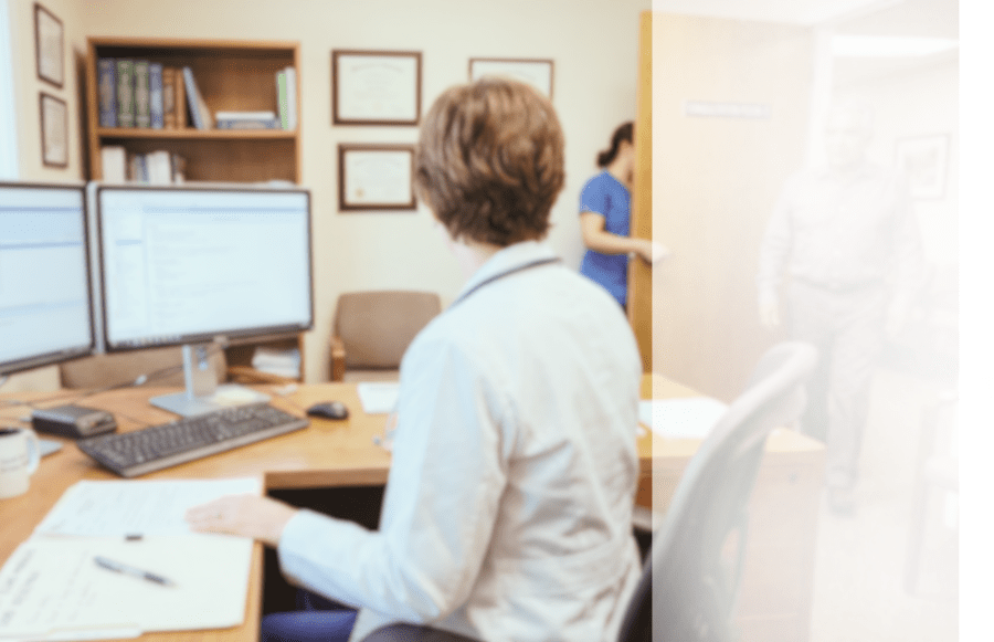 Physician using VoiceboxMD medical dictation software at workstation with EHR